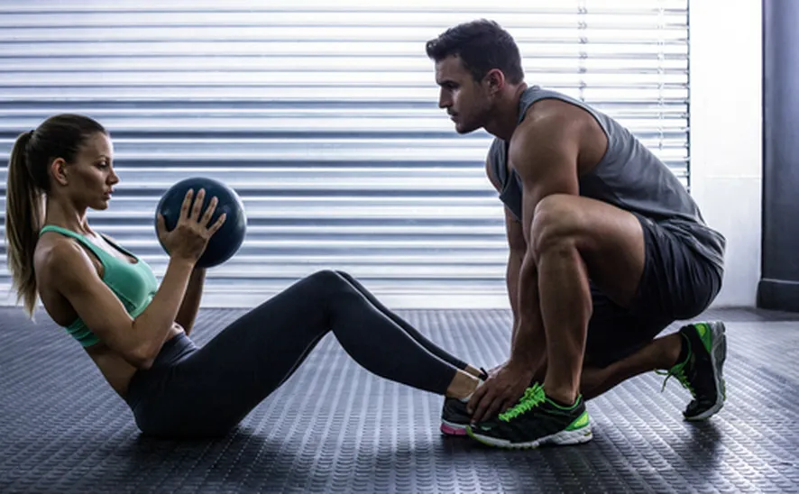 Personal trainer helping client